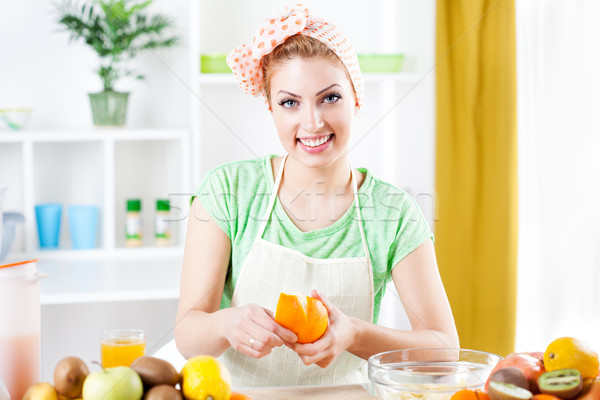 Stock photo: Young woman peeling oranges