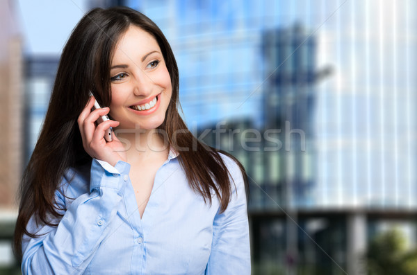 Attractive businesswoman talking on mobile phone in an office Stock photo © Minervastock