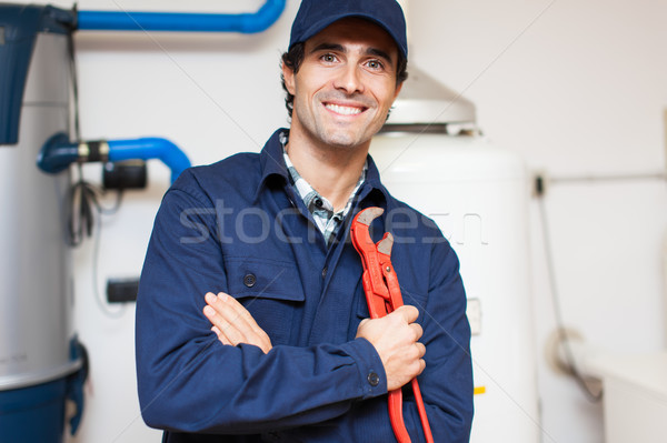 Smiling technician repairing an hot-water heater Stock photo © Minervastock