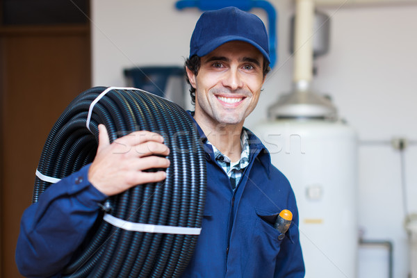 Portrait of a smiling worker carrying corrugated conduit Stock photo © Minervastock