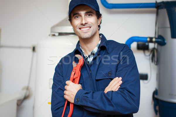 Smiling technician repairing an hot-water heater Stock photo © Minervastock