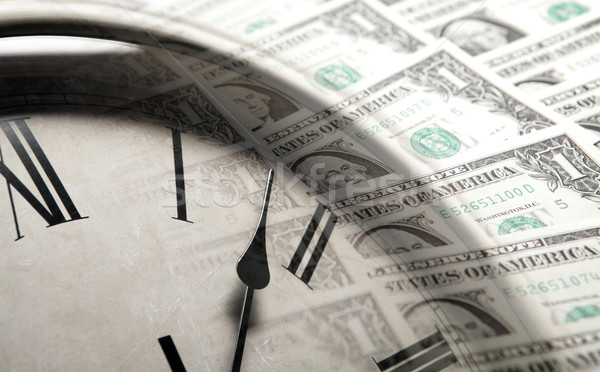 Stock photo: clock on the background of banknotes dollars