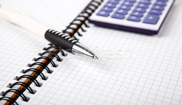 pen on a notebook into a cell and calculator Stock photo © mizar_21984