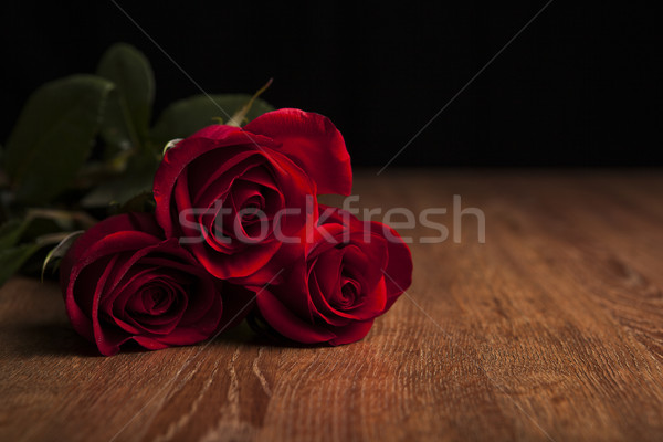 bouquet of roses lying on a wooden table on a black background Stock photo © mizar_21984