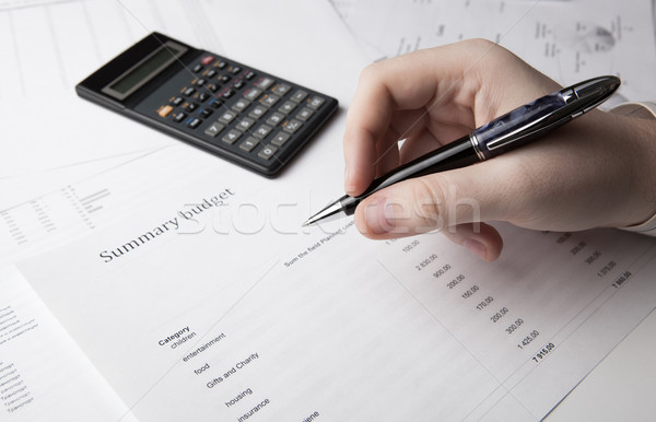 businessman holding a pen and counts the budget Stock photo © mizar_21984