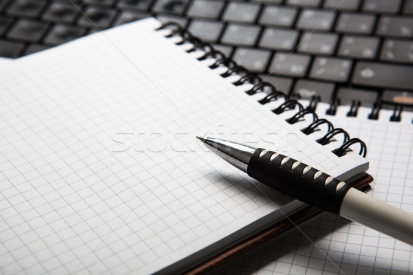 pen on a notebook into a cell and keyboard Stock photo © mizar_21984