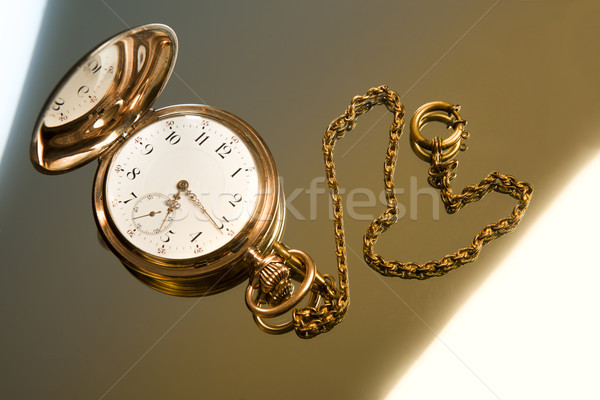 Gold pocket watch on gold glass background Stock photo © mizar_21984