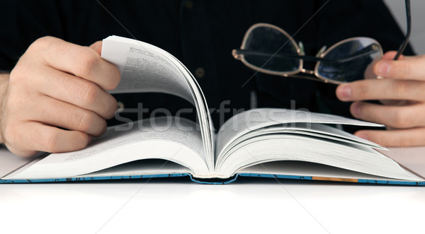 Man's hands and man looking for something in the book Stock photo © mizar_21984