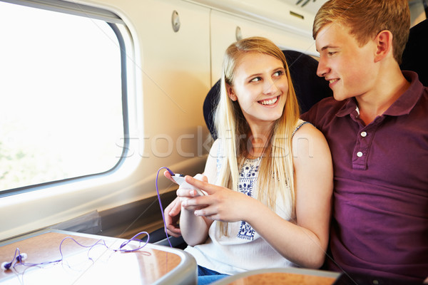 Fiatal pér zenét hallgat vonat utazás férfi nők Stock fotó © monkey_business