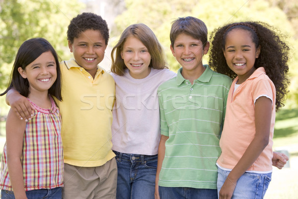 Vijf jonge vrienden permanente buitenshuis glimlachend Stockfoto © monkey_business