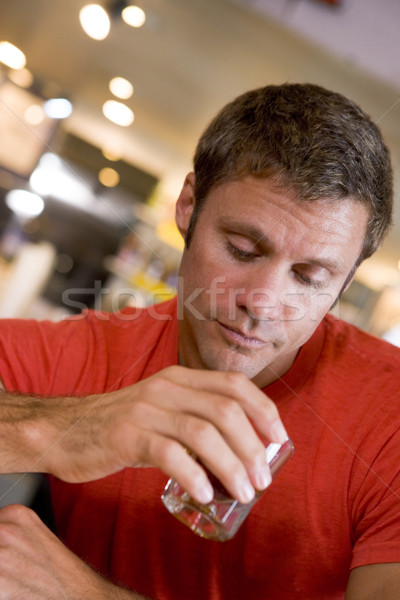 Young man at bar staring forlornly into drink Stock photo © monkey_business