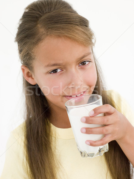 Stock photo: Young girl drinking glass of milk