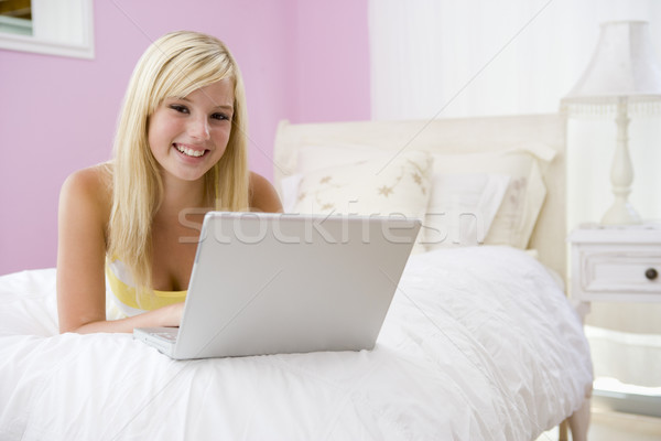商業照片: 十幾歲的女孩 · 床 · 使用筆記本電腦 · 計算機 · 因特網 · 快樂