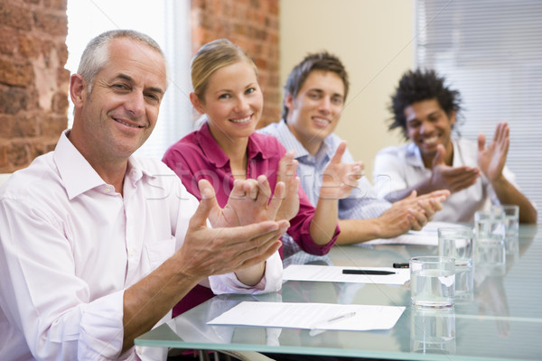 Four businesspeople in boardroom applauding and smiling Stock photo © monkey_business