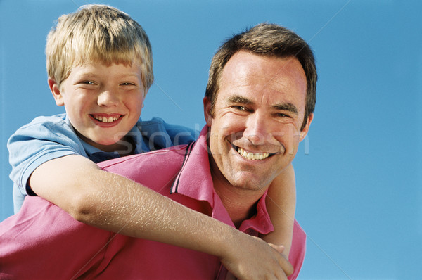 Vader zoon op de rug buitenshuis glimlachend familie Stockfoto © monkey_business