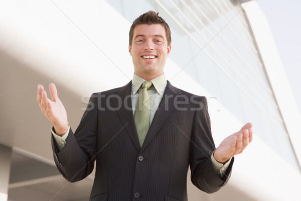 Businessman standing outdoors by building with hands out Stock photo © monkey_business