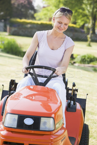 Woman outdoors driving lawnmower smiling Stock photo © monkey_business