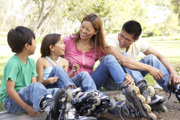 Stock photo: Family Putting On In Line Skates In Park