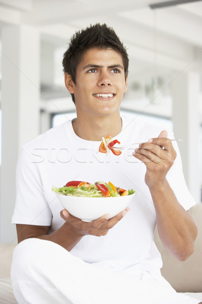 Junger Mann Essen Salat Essen Mann glücklich Stock foto © monkey_business