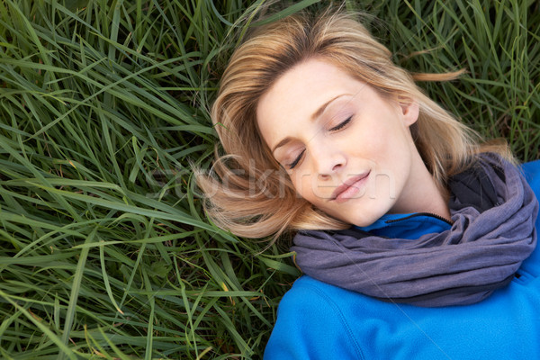 Young woman napping alone on grass Stock photo © monkey_business
