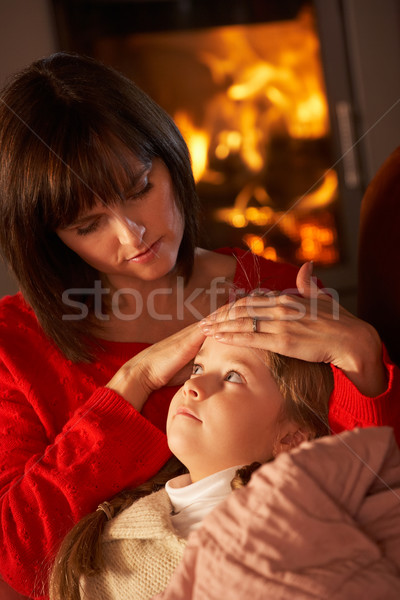 Mother Comforting Sick Daughter On Sofa By Cosy Log Fire Stock photo © monkey_business