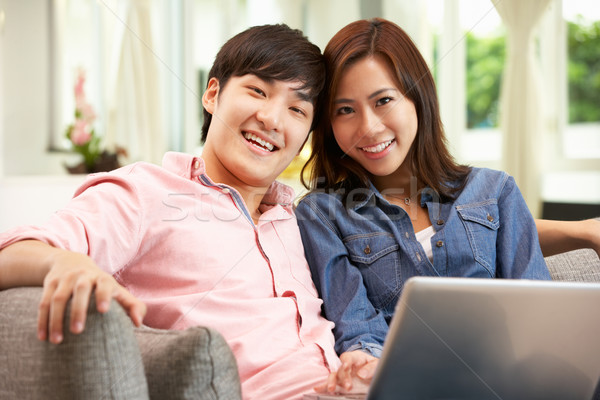 Foto stock: Jovem · chinês · casal · usando · laptop · relaxante · sofá