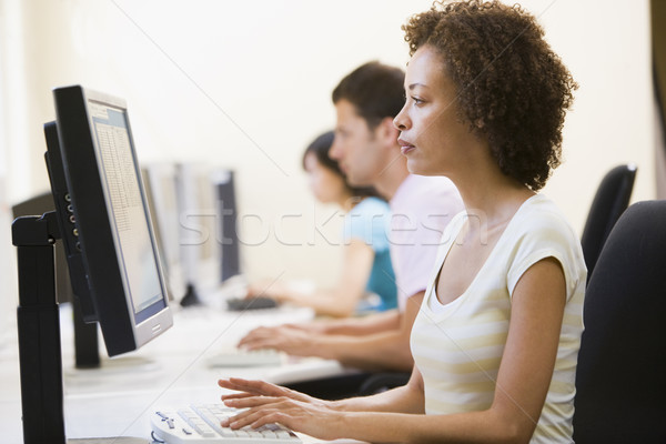Trei persoane sala de calculatoare dactilografiere femeie birou grup Imagine de stoc © monkey_business