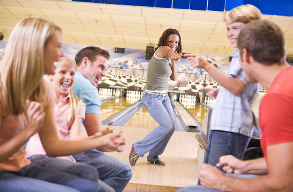 Family in bowling alley with two friends cheering and smiling Stock photo © monkey_business