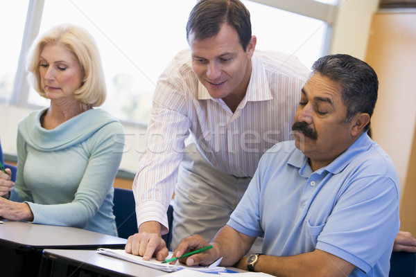 Teacher assisting mature student in class Stock photo © monkey_business