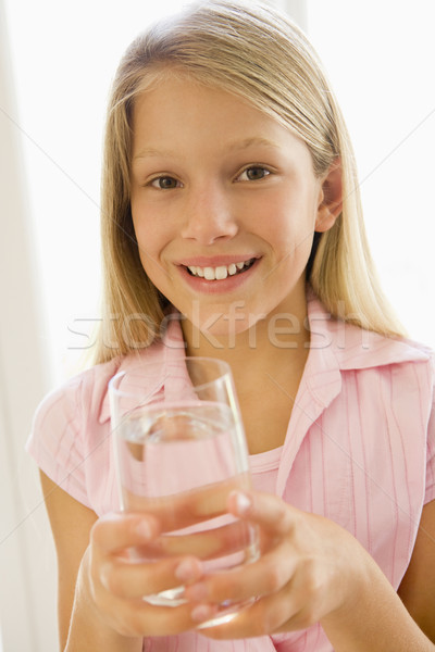Stock photo: Young girl indoors drinking water smiling