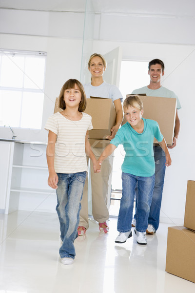 Family with boxes moving into new home smiling Stock photo © monkey_business