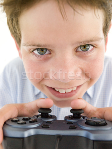 Young boy using videogame controller smiling Stock photo © monkey_business
