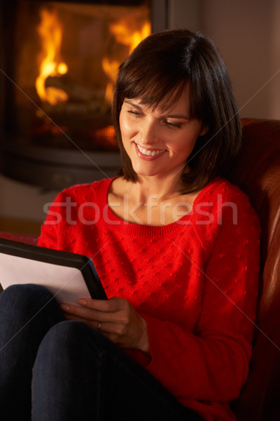 Middle Aged Woman Using Tablet Computer By Cosy Log Fire Stock photo © monkey_business