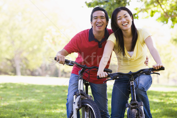 Couple on bikes outdoors smiling Stock photo © monkey_business