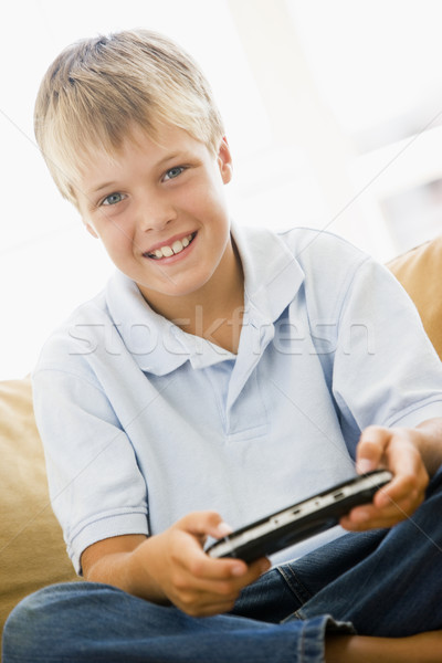 Young boy in living room with handheld video game smiling Stock photo © monkey_business