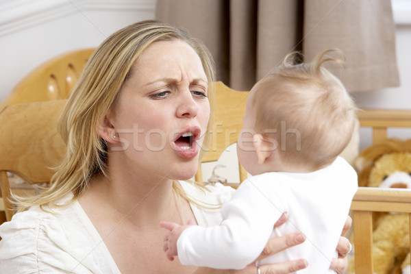 Stock photo: Stressed Mother Holding Baby In Nursery