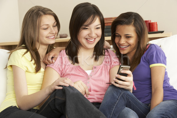 Tini barátnők olvas mobiltelefon otthon telefon Stock fotó © monkey_business