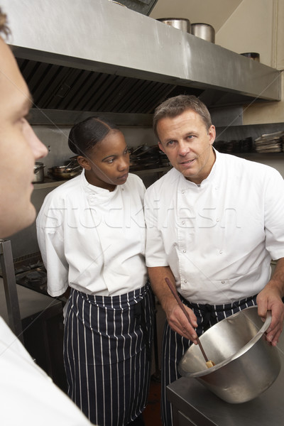 Chef Instructing Trainees In Restaurant Kitchen Stock photo © monkey_business