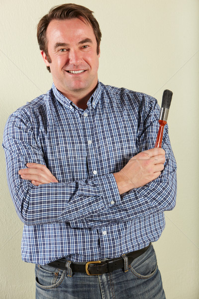 Stock photo: Studio Shot Of Middle Aged Man Holding Paintbrush
