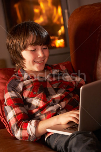 Young Boy Relaxing With Laptop By Cosy Log Fire Stock photo © monkey_business