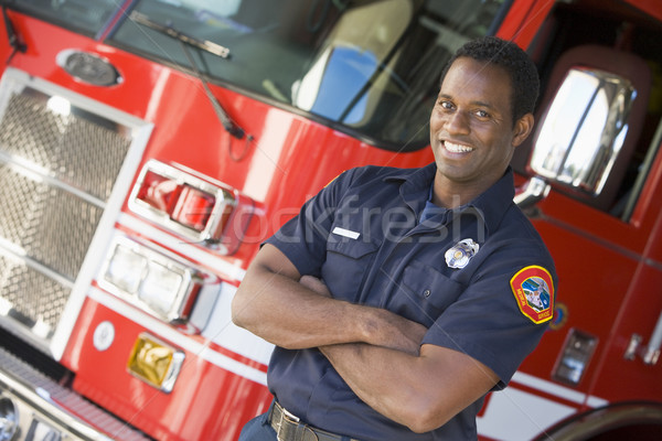Stock photo: Portrait of a firefighter by a fire engine