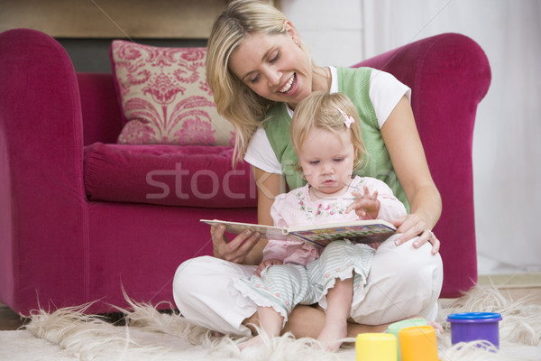 Mother in living room reading book with baby smiling Stock photo © monkey_business