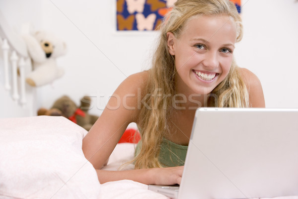 Stock photo: Teenage Girl Lying On Her Bed Using Laptop
