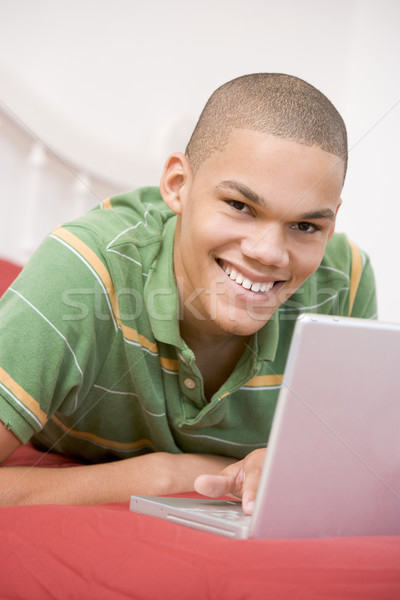 Stock photo: Teenage Boy Lying On Bed Using Laptop 
