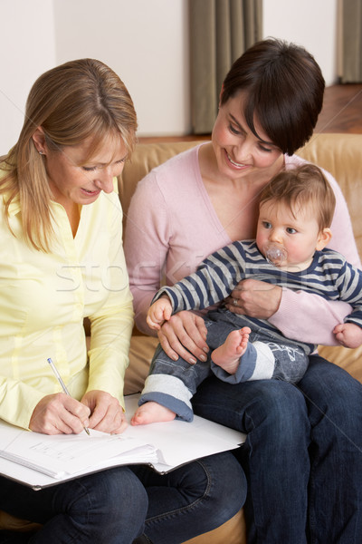 Mother With Baby Talking With Health Visitor At Home Stock photo © monkey_business