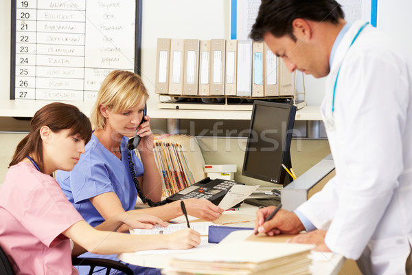 Doctor With Two Nurses Working At Nurses Station Stock photo © monkey_business