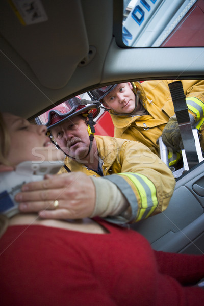 Stock photo: Firefighters helping an injured woman in a car