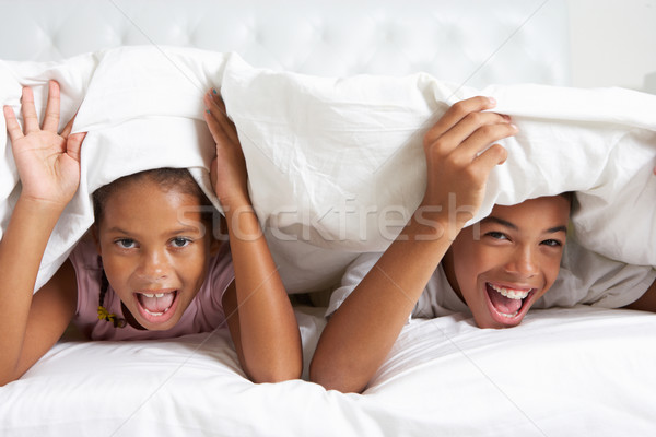 Two Children Hiding Under Duvet In Bed Stock photo © monkey_business