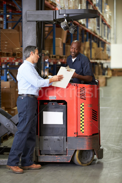 Stock photo: Fork Lift Truck Operator Talking To Manager In Warehouse