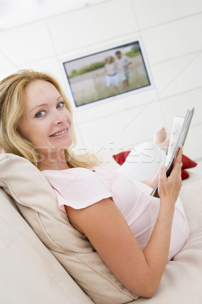 Femeie gravida lectură revistă televiziune femeie familie Imagine de stoc © monkey_business